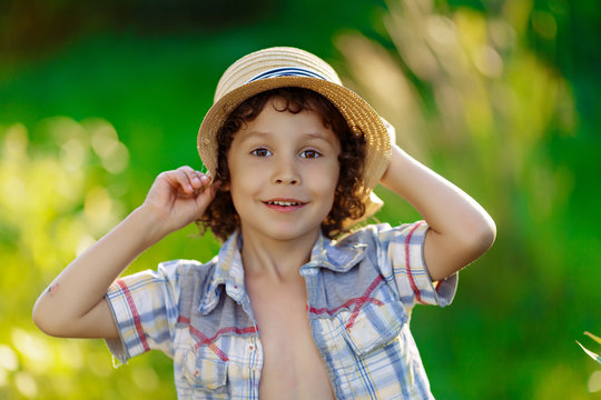 curly dark-haired boy in the summer depicts different emotions, close-up