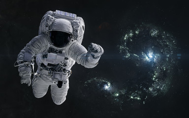 Fototapeta na wymiar Astronaut on a background of colliding blue galaxies. Science fiction. Elements of this image furnished by NASA
