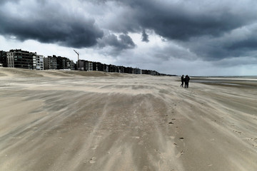 People are walking on the beach during a hurricane-like storm in Koksijde, Flanders, Belgium, Europe