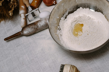 Broken egg with yolk in a bowl with flour. The recipe for the dough