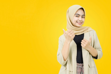 Wow and surprised face of Asian female with hand point on yellow background