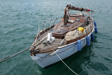 View of a shipwrecked sailing boat with broken mast in the harbor