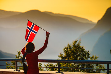 Tourist with norwegian flag and mountains landscape