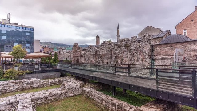 Historical Taslihan ruins timelapse with the old watch tower and minaret of Gazi Husrev mosque at the background, Sarajevo, Bosnia and Herzegovina. Footbridge and wall