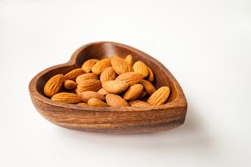 Almond nuts in bamboo wooden bowl on white background isolated