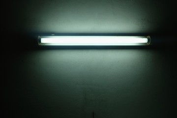 White old fluorescent lamp on cement wall