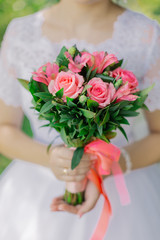 Obraz na płótnie Canvas Young happy bride with a wedding bouquet by a bouquet.