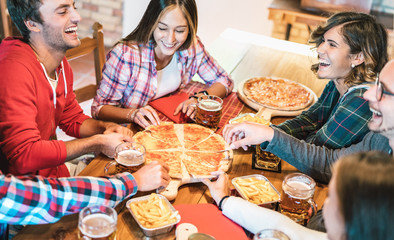 Young friends on genuine laugh while eating pizza at home on family reunion - Friendship concept...