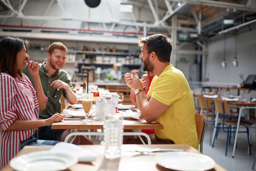 group of young adults talking and smiling in restaurant