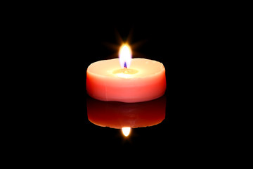 One pink tea light candle isolated on black glass with reflection