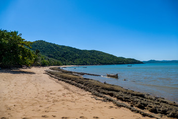 Coastline / Beach of Nosy Komba Island lined with palm trees and pirogue Madagascar close to Nosy Be