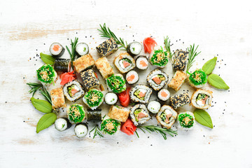 Set of tasty sushi and maki rolls on white wooden background. Japanese food. Top view. Free space for your text.