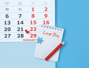 Calendar with marking in red pin of 29 february date. February month, calendar, notebook, pencil. leap day in leap year concept. 