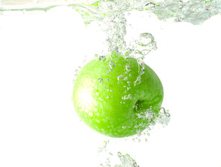 Green apple in splash of water isolated on white background