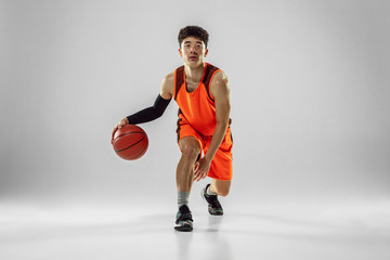 Young basketball player of team wearing sportwear training, practicing in action, motion in run...