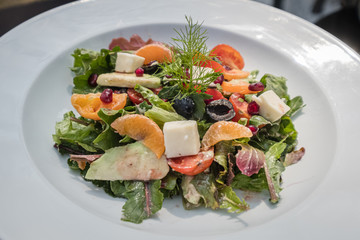 A healthy mixed salad in a white bowl