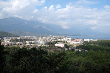 Fototapeta na wymiar View from observing place point to valley with Kemer city in Antalya region surrounded by high mountains and calm blue Mediterranean sea on bright sunny day