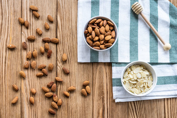 nuts in bowl on a wooden background. Rustic style. Almonds on a towel. Vegetarian food.
