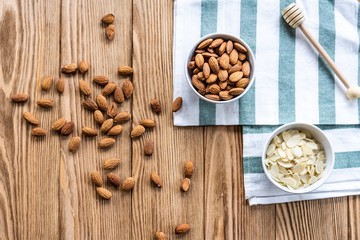 nuts in bowl on a wooden background. Rustic style. Almonds on a towel. Vegetarian food.