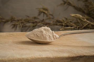 Teff flour on a spoon with a rustic background