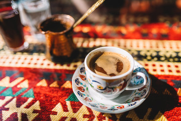 Authentic turkish coffee and a copper coffee pot in a turkish restaurant/cafe - obrazy, fototapety, plakaty