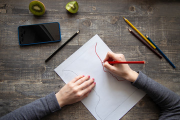 young girl draws with pencils