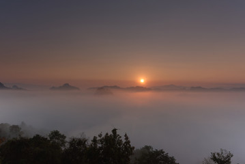 Fototapeta premium Beutiful sea of fog in a valley with orange sky cloud in a sunrise time