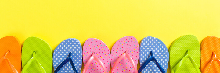 a lot of flip flop colored sandals, summer vacation on colored background, banner copy space top...