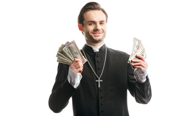 corrupt catholic priest smiling at camera while holding dollar banknotes isolated on white