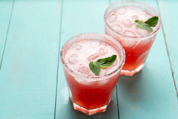 Mexican watermelon margarita cocktail on turquoise background