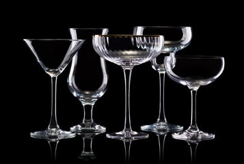 Set of different empty glasses for drinks on black background