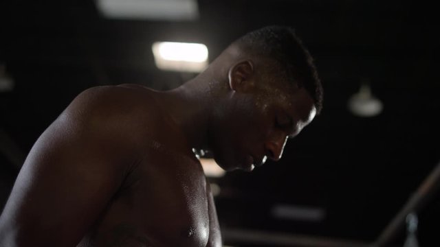 Shirtless African American man breathing after boxing workout