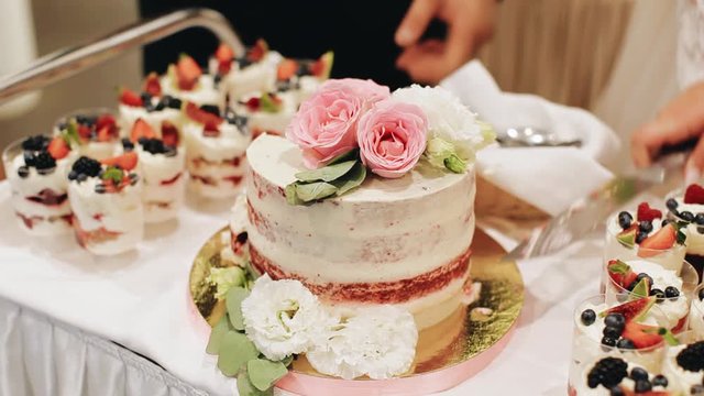 Lovers are preparing to cut the wedding cake. Wedding celebration. Tasty treat.