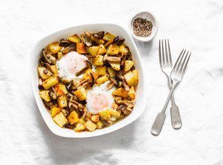 Baked potatoes with mushrooms and eggs - delicious lunch, breakfast, snack on a light background, top view