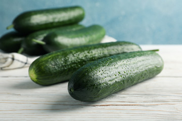 Cucumbers and towel on wooden background, close up