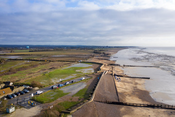 Obraz premium Climping beach after storm ciara damaged the sea defences which were breached by sea water causing flooding, diggers and bulldozers repair the sea defences.