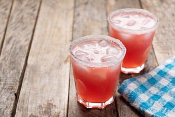 Mexican watermelon margarita cocktail on wooden background