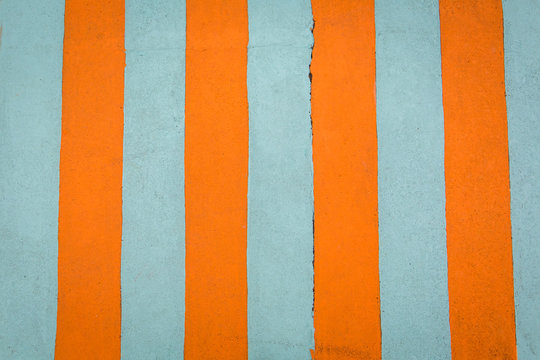 orange and turquoise bright colored striped cement painted wall great for a background. beach themed with vibrant colors