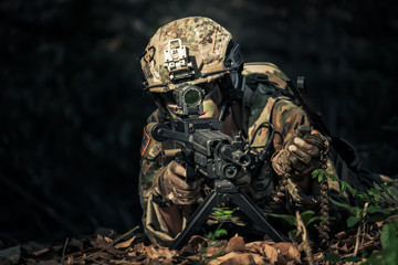 special forces soldier assault rifle with silencer.  Sniper in the forest.