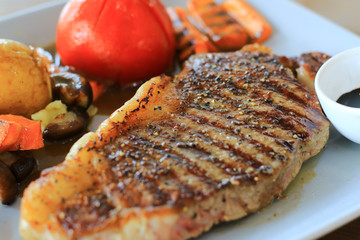Homemade grill rib eye steak with vegetable mushroom and mashed potato top with gravy,  balsamic sauce on side cup. Western cuisine are popular.