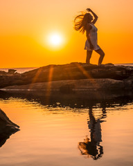 Lifestyle, silhouette of a young blonde on the coast at a sunset