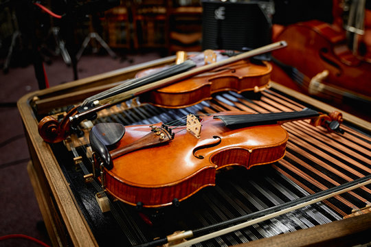 Old antique violin lying on a dulcimer in a moody warm room