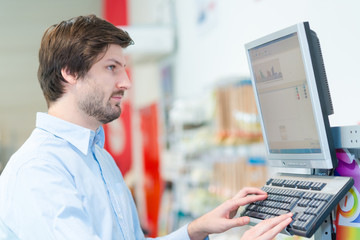 man with computer checking stock in computer