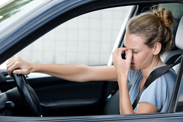 closeup portrait of young woman feels headache in her car