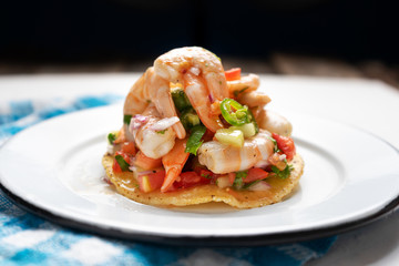 Mexican shrimp ceviche toast also called tostada on black background