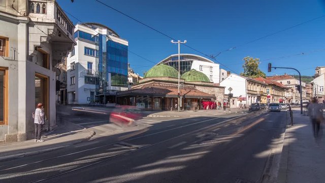 Bosniak Institute timelapse hyperlapse, in a renovated Turkish bathhouse, includes a library and art collection focusing on Bosniak culture. Street with cars and public transport at Sarajevo city