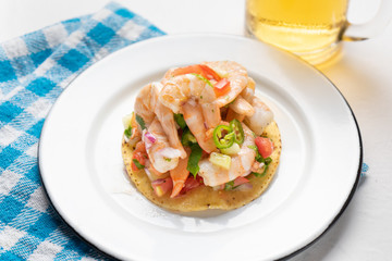 Mexican shrimp ceviche toast also called tostada on white background