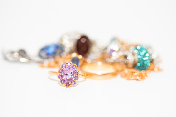 Collection of jewelry with beautiful golden ring with purple stone isolated on white background
