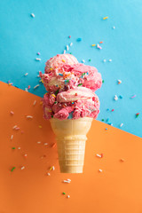 ice cream on a cone in front of blue and orange background - 323047551