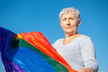 older woman with lgbt flag and blue background